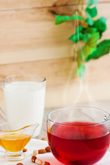 Honey, raspberry jam, milk, towel on rustic background. Candied fruits on a towel. Healthy food. Breakfast. White napkin on the table. The background. Frame

