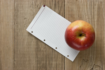 apple and a note  on a wooden background