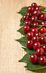 Berry Cherry with leaves on wooden background