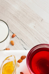 Honey, raspberry jam, milk, towel on rustic background. Candied fruits on a towel. Healthy food. Breakfast. White napkin on the table. The background. Frame
