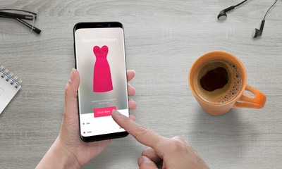 Online shopping with modern mobile phone. Woman use online store to buy pink dress. Modern smart...