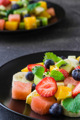 Fresh fruit salad on dark background. Close up