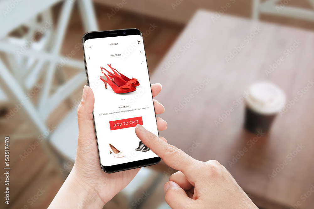Poster Online store app use on modern mobile phone with round edges. Woman touch add to cart button for red shoes.