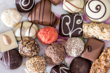 Top view on different of delicious chocolate candies, white, dark, and milk chocolate.