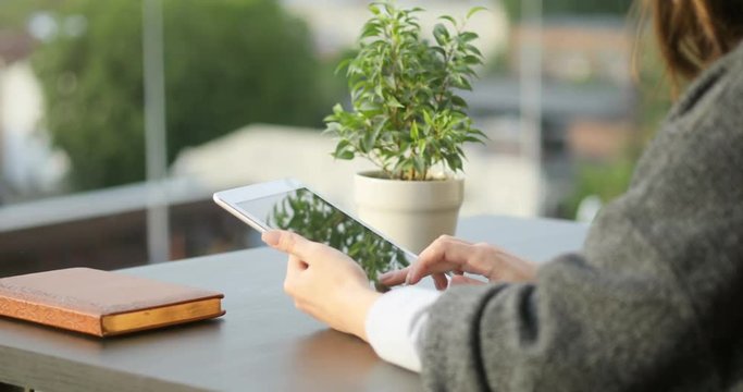 Cute girl hands holding tablet computer and texting messages, scrolling using app industrial background text, video calls, surfing Internet, office outdoors cafe terrace 4k sunset sun vintage retro