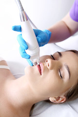 Podciśnieniowy masaż twarzy przy użyciu specjalnej głowicy. Kobieta w klinice medycyny...