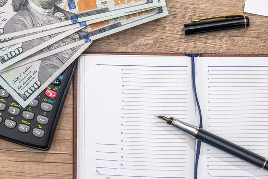 empty notepad, pen, doolar and coin on desk