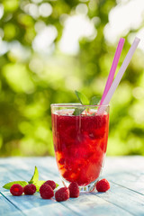 Glass of lemonade with raspberries and mint leaves