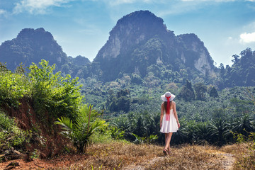 Girl goes on a footpath in the tropics of Thailand