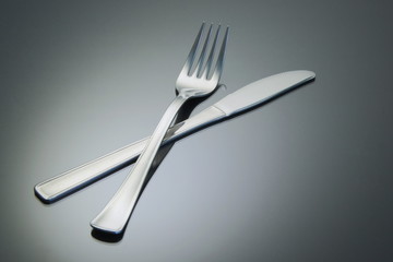 Fork and knife on a reflective surface
