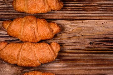 Fresh croissants on wooden table. Top view