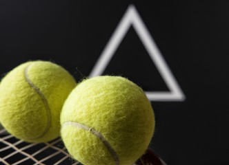 Tennis racket with a ball on a black background