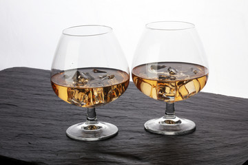 glass of whiskey with ice on a wooden