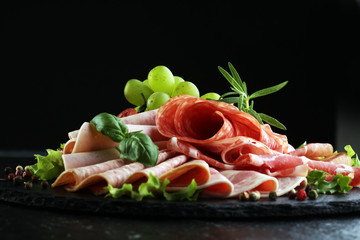 Food tray with delicious salami, pieces of sliced ham, sausage, tomatoes, salad and vegetable - Meat platter with selection