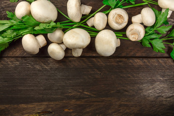 Overhead photo of white mushrooms with green parsley leaves