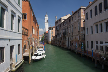 Building with balconies and flowers in an old canal in Venice, Italy