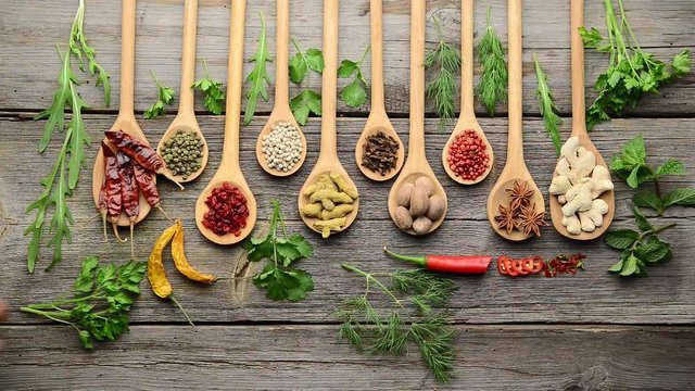 Different spices and fresh herbs on a wooden table