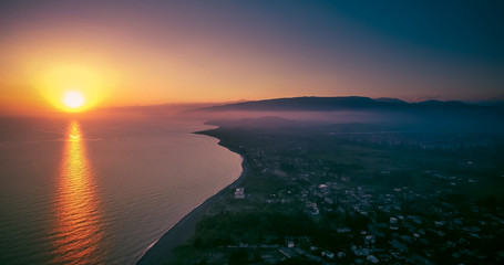 Obraz premium sunset over water surface of the sea from the height of bird flight