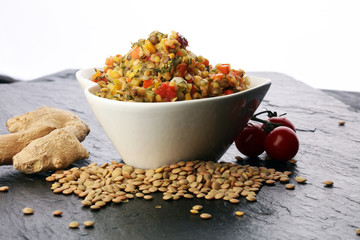 Lentil with carrot and pumpkin ragout in a wooden bowl on a wooden background