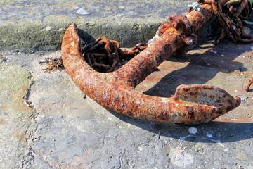 Rusty old disused anchor on a quayside