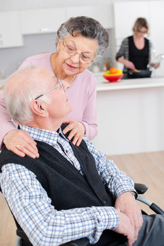 Elderly woman embracing her husband