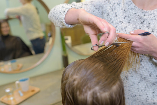 Hairdresser cutting wet hair