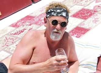 An englishman with a beard wearing a bandana and cool sunglasses while on vacation, 2017