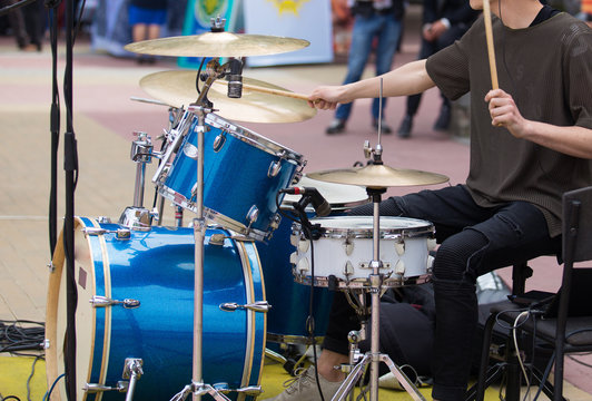 young drummer playing on city street