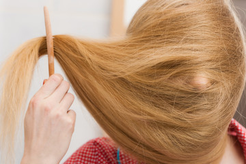 Woman face covered with blonde long hair