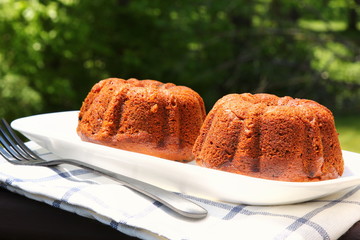 Small banana and dates bread Bundt cakes on a wooden background with copy space