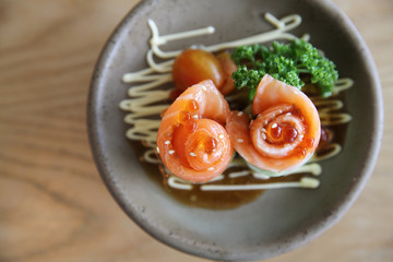 Salmon sashimi with cucumber on wood