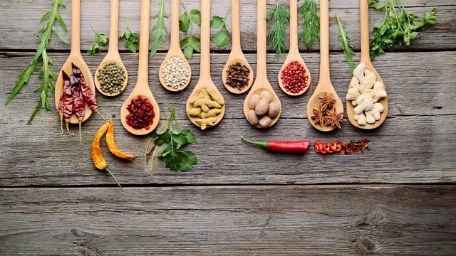 Different spices and fresh herbs on a wooden table