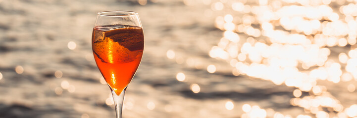 Aperol spritz at a wooden pier at sunset. Luxury resort vacation concept. Festive relax getaway...