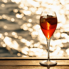 Aperol spritz at a wooden pier at sunset. Luxury resort vacation concept. Festive relax getaway background.