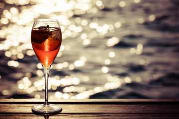 Aperol spritz at a wooden pier at sunset. Luxury resort vacation concept. Festive relax getaway...