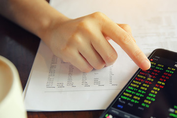 trading online on smartphone with bussiness woman hand