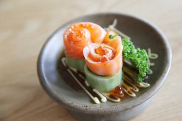 Salmon sashimi with cucumber on wood