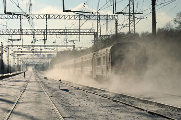 A passenger train goes by rail in winter