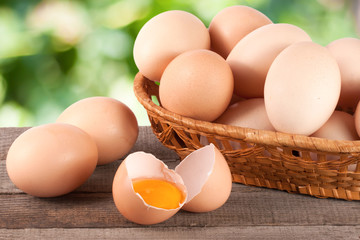 eggs in a wicker basket on a wooden board with blurred garden background
