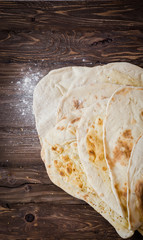 Homemade freshly baked Flatbread - Middle Eastern multi seeded flatbread with seasame seeds on woode3n background. Toned image