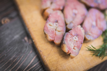 Steaks of red smoked fish and dill on the right side of the frame