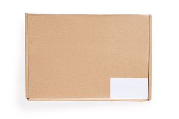 Closed cardboard box with blank white label. Isolated on white, clipping path included.