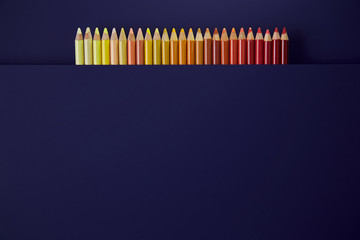 Colour pencils isolated on purple background close up