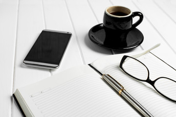 Cup of coffee notepad glasses phone