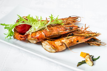 Delicious delicacy. Large ready royal prawns, decorated with herbs. Horizontal frame