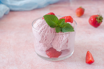 Portion of Strawberry ice cream with chocolate drops in glass on stone background. Selective focus