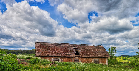 Blue cloudy sky over stork sitting on the edge of barn, HDR image, Poland, Europe