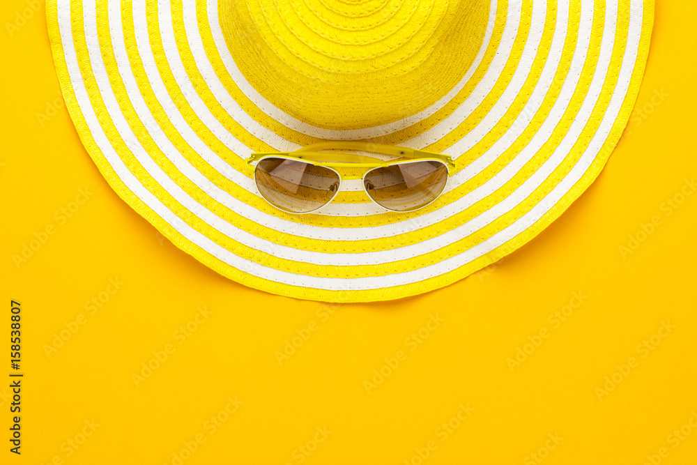 Wall mural yellow sunglasses and striped retro hat. summer concept