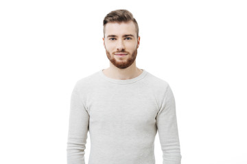 Portrait of young handsome man looking at  the camera over white background. Attractive bearded guy...