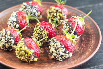 Fresh strawberries covered with dark chocolate and nuts